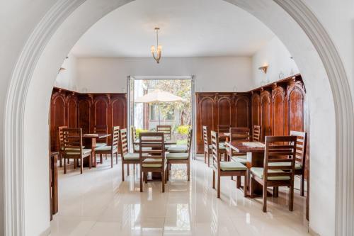 un arco in una sala da pranzo con sedie e tavoli in legno di Hotel Quinta Allende a Querétaro
