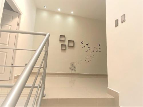 a staircase with birds flying in a white room at Casa nueva recien equipada y completa. in Chihuahua