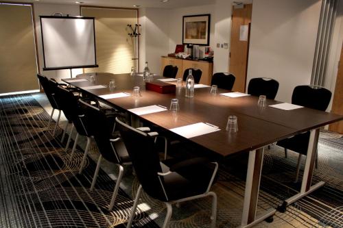 a conference room with a large table and chairs at Holiday Inn Newcastle-Jesmond by IHG in Newcastle upon Tyne