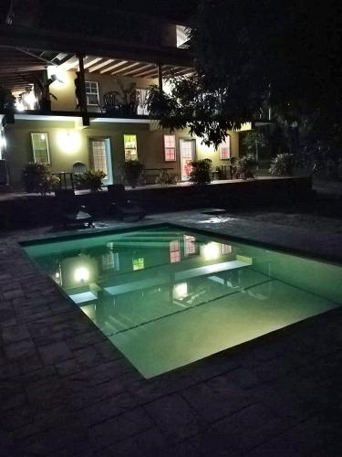 a swimming pool at night with lights in it at Tropical Apartments Tobago in Scarborough