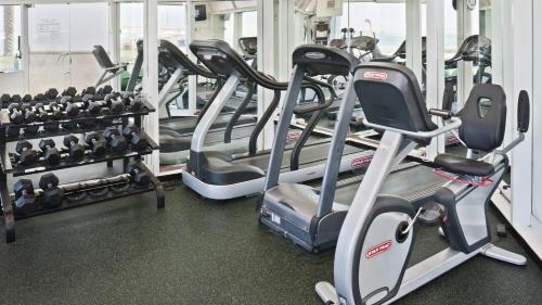 a gym with rows of treadmills and machines at Vert Dead Sea by AFI Hotels in Ein Bokek