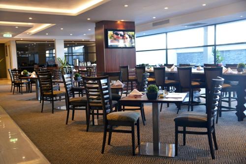 a dining room with tables and chairs in a restaurant at Indaba Lodge Gaborone in Gaborone