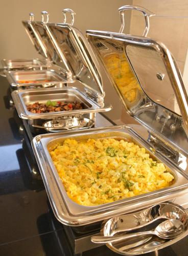 a buffet with several trays of food on a table at Indaba Lodge Gaborone in Gaborone