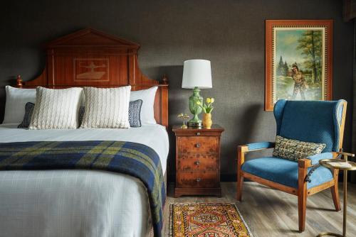a bedroom with a bed and a blue chair at Graduate by Hilton Ann Arbor in Ann Arbor