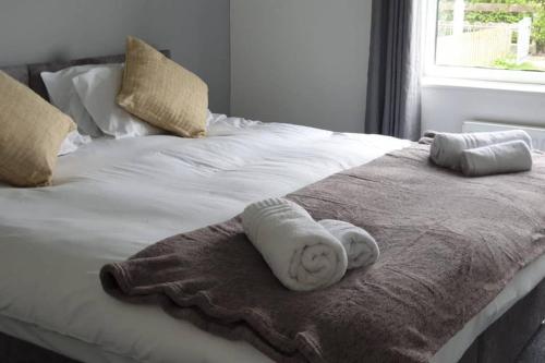 a bed with two towels on it with a window at Stay Newbiggin-By-The-Sea in Woodhorn