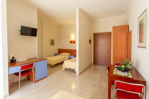 ein Hotelzimmer mit einem Schreibtisch und einem Schlafzimmer in der Unterkunft Il Viandante Catenanuova in Catenanuova