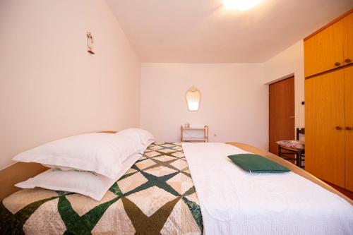 a bedroom with a large bed with two pillows at Apartman Jadranka in Zadar