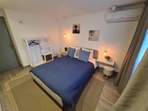 een slaapkamer met een bed met een blauwe sprei bij NinePlace by LouzanPlace's in Lousã