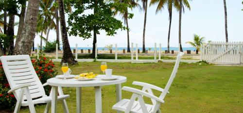 a table with a plate of fruit and two chairs at Villa directly on the beach, las Ballenas in Las Terrenas