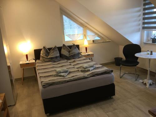 1 dormitorio con 1 cama, mesa y sillas en H&E Apartments, en Steinheim