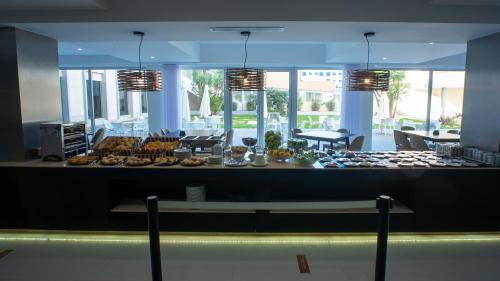 a buffet line with food on a table in a building at QH Praia de Quiaios in Praia de Quiaios