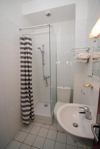 une salle de bain avec une douche, des toilettes et un lavabo dans l'établissement Hôtel Le Bellevue - Paris Porte d'Orléans, à Cachan