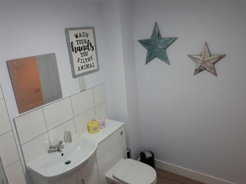 baño con aseo y estrellas en la pared en RentUnique St Georges 2x 2 bed amazing apartments moments from centre en Horley