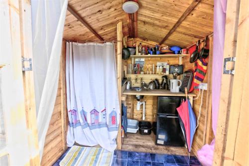 eine kleine Küche in einem winzigen Haus mit Fenster in der Unterkunft Willow Barn in Wisbech