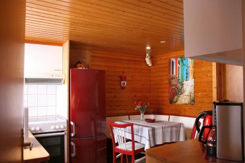 eine Küche mit einem Tisch und einem roten Kühlschrank in der Unterkunft Ferienhaus Sequoia Hahnenklee in Hahnenklee-Bockswiese