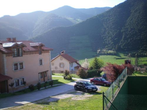 a house and a car parked in front of a mountain at Casa Rural Alquitara in Ojedo
