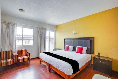 a bedroom with a large bed with red pillows at Hotel Patzcuaro in Pátzcuaro