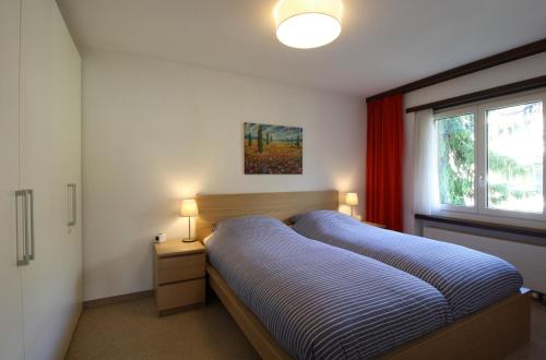 Un dormitorio con una cama azul y una ventana en Palousa 3001 Na, en Valbella