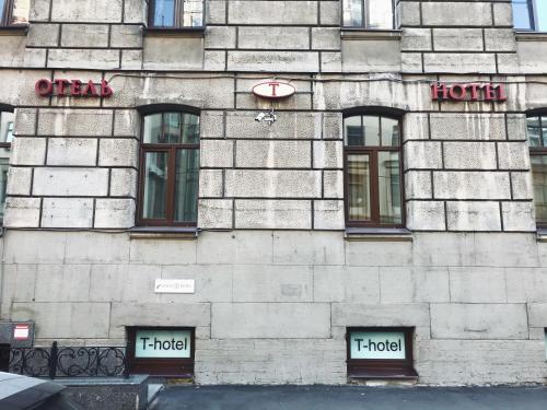 a building with three windows and a hotel sign on it at T-Hotel in Saint Petersburg