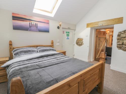 a bedroom with a wooden bed in a room at Dovecote Cottage in Scarborough