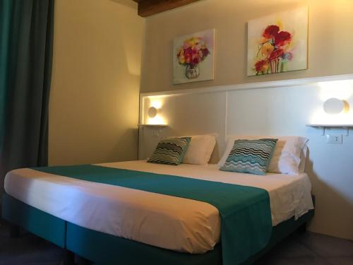 a bedroom with two beds and two paintings on the wall at Residenza Vinci Room & Suite in Pizzo