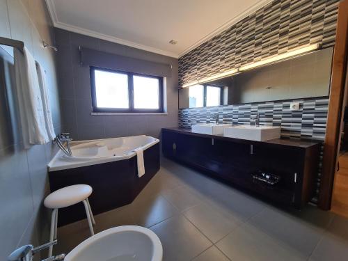 uma casa de banho com uma banheira, um lavat�rio e um WC. em Quinta de Santo Est�v�o Hotel Rural em Aguiar da Beira