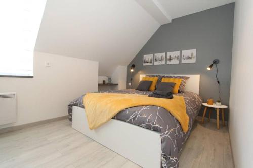 a bedroom with a king sized bed in a attic at Le City by EasyEscale in Romilly-sur-Seine