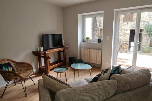 a living room with a couch and chairs and a tv at La Paulée à Pommard in Pommard