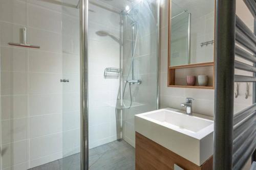 La salle de bains est pourvue d'un lavabo et d'une douche. dans l'établissement Meribel Le Creux de l'Ours, à Les Allues