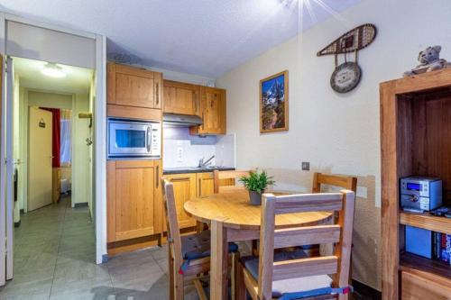 a kitchen and dining room with a table and chairs at Le Creux de l'Ours - au pied des pistes - animaux acceptés in Méribel