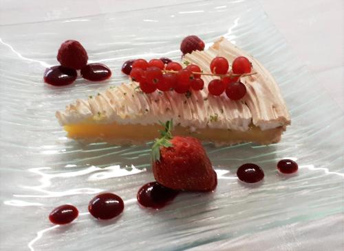 a piece of cake with strawberries and cherries on a plate at Logis La Rose Des Vents in Volvic