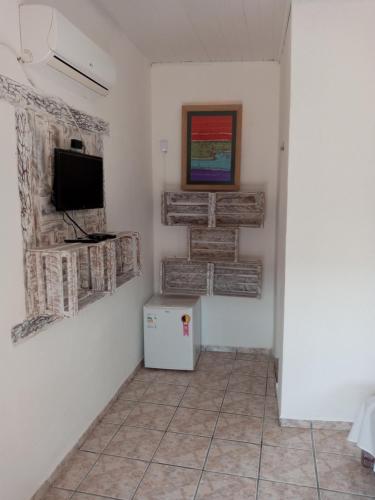 Habitación con TV y suelo de baldosa. en Pousada Olhar da Sereia, en Arraial d'Ajuda