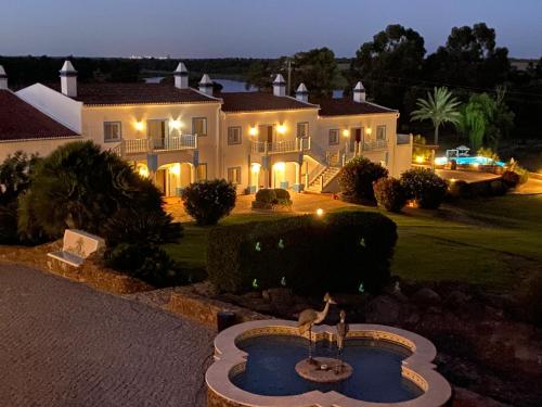 a large house with a fountain in front of it at Herdade dos Grous in Albernoa