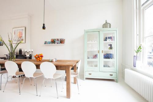 a dining room with a wooden table and white chairs at Mokum Suites in Amsterdam
