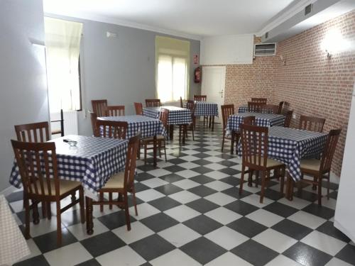 comedor con mesas y sillas y suelo a cuadros en Hostal El Fogon De Felisa, en Herrera del Duque