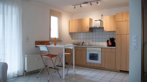 a kitchen with a table and two chairs in it at Gemütliche Wohnung mit sonniger Terrasse in Bietigheim-Bissingen