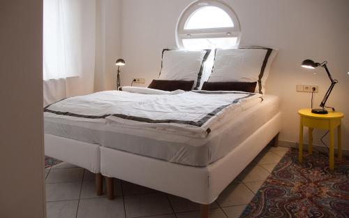 a bedroom with a large white bed with a window at Gemütliche Wohnung mit sonniger Terrasse in Bietigheim-Bissingen