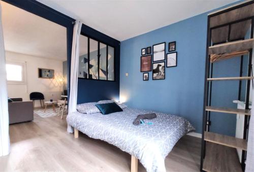 une chambre avec un lit et un mur bleu dans l'établissement L'ÉGLANTINE - Proche Centre - Free Parking - Airbus, à Toulouse