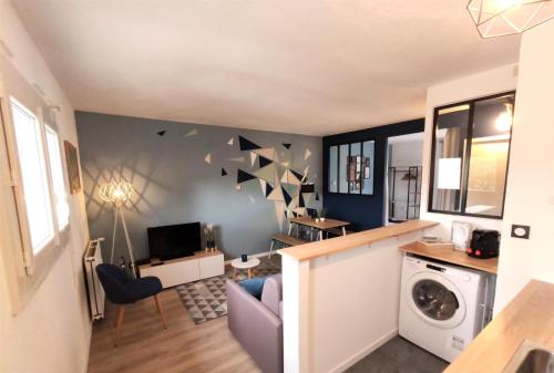 - un salon avec une table et un lave-linge dans l'établissement L'ÉGLANTINE - Proche Centre - Free Parking - Airbus, à Toulouse