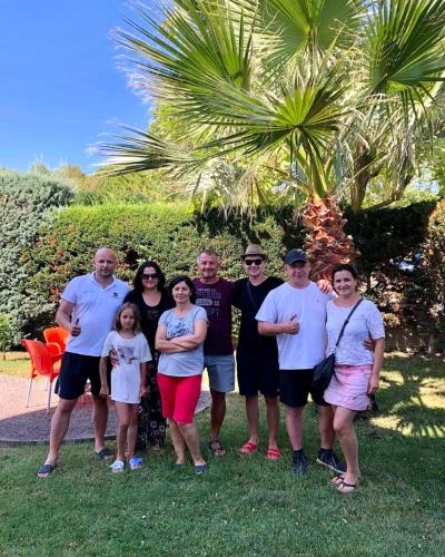 a family posing for a picture in front of a palm tree at Eleart in Golem