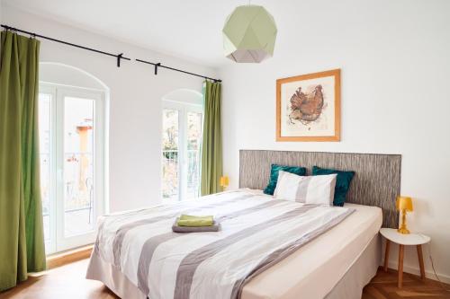 a bedroom with a large bed with green curtains at Beautiful Backyard Remise in Berlin
