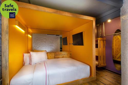 a small bedroom with a bed in a yellow room at Hotel MX roma in Mexico City
