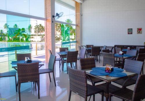 une salle à manger avec des tables et des chaises ainsi qu'une piscine dans l'établissement Flat Porto de Galinhas, à Porto de Galinhas