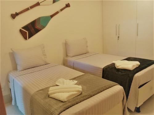 a room with two beds with towels on them at La Fleur Polinésia in Porto De Galinhas