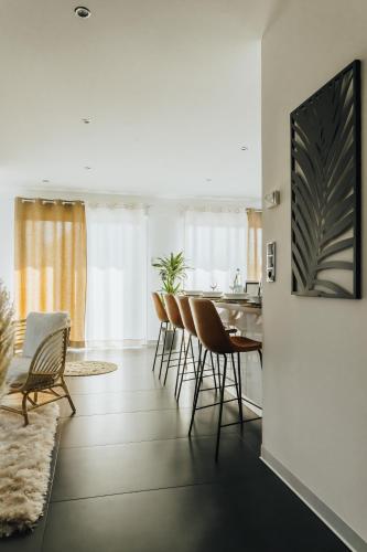 une cuisine et un salon avec une table et des chaises dans l'établissement La Villetta S Blotzheim - Appartement de Standing, à Blotzheim