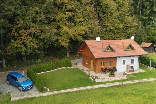 a small house with a car parked in front of it at Panoramablick in Langegg an der Schilcherstraße