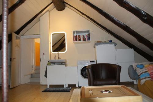 Cette chambre mansardée comprend un bureau et une chaise. dans l'établissement Airolo with private parking, à Airolo