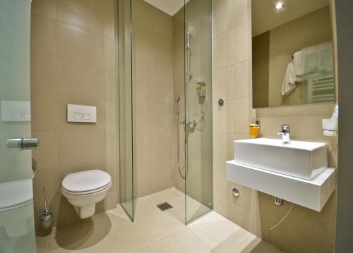 y baño con aseo, lavabo y ducha. en Garni Hotel Krevet&Dorucak, en Niš