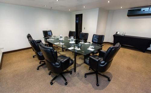 a conference room with a table and black chairs at J&A Classic Hotel in Lima