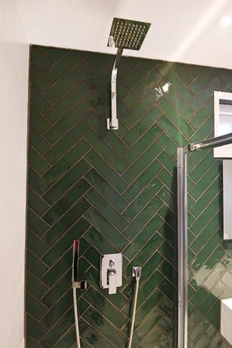 a bathroom with a shower with a green tiled wall at Chalet Santpoort-Zuid in Santpoort-Zuid